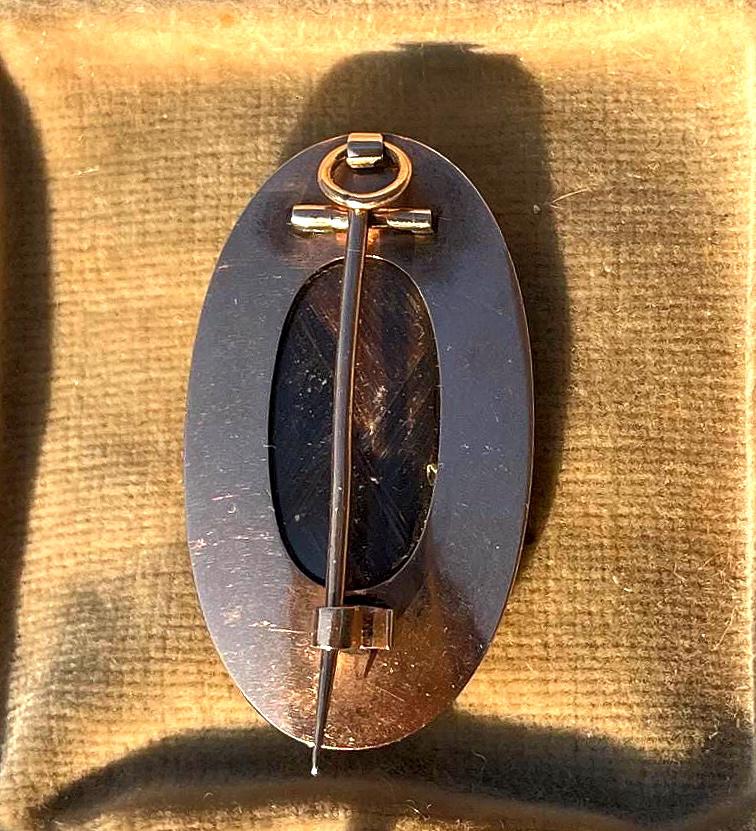 Broche relicario de luto georgiano antiguo del siglo XVIII en oro con esmalte blanco, perla, cabello y motivo de urna.