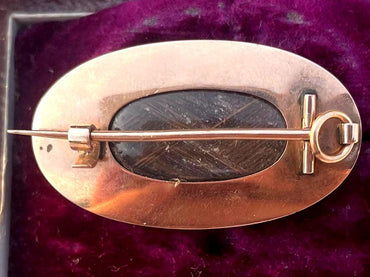 Broche relicario de luto georgiano antiguo del siglo XVIII en oro con esmalte blanco, perla, cabello y motivo de urna.