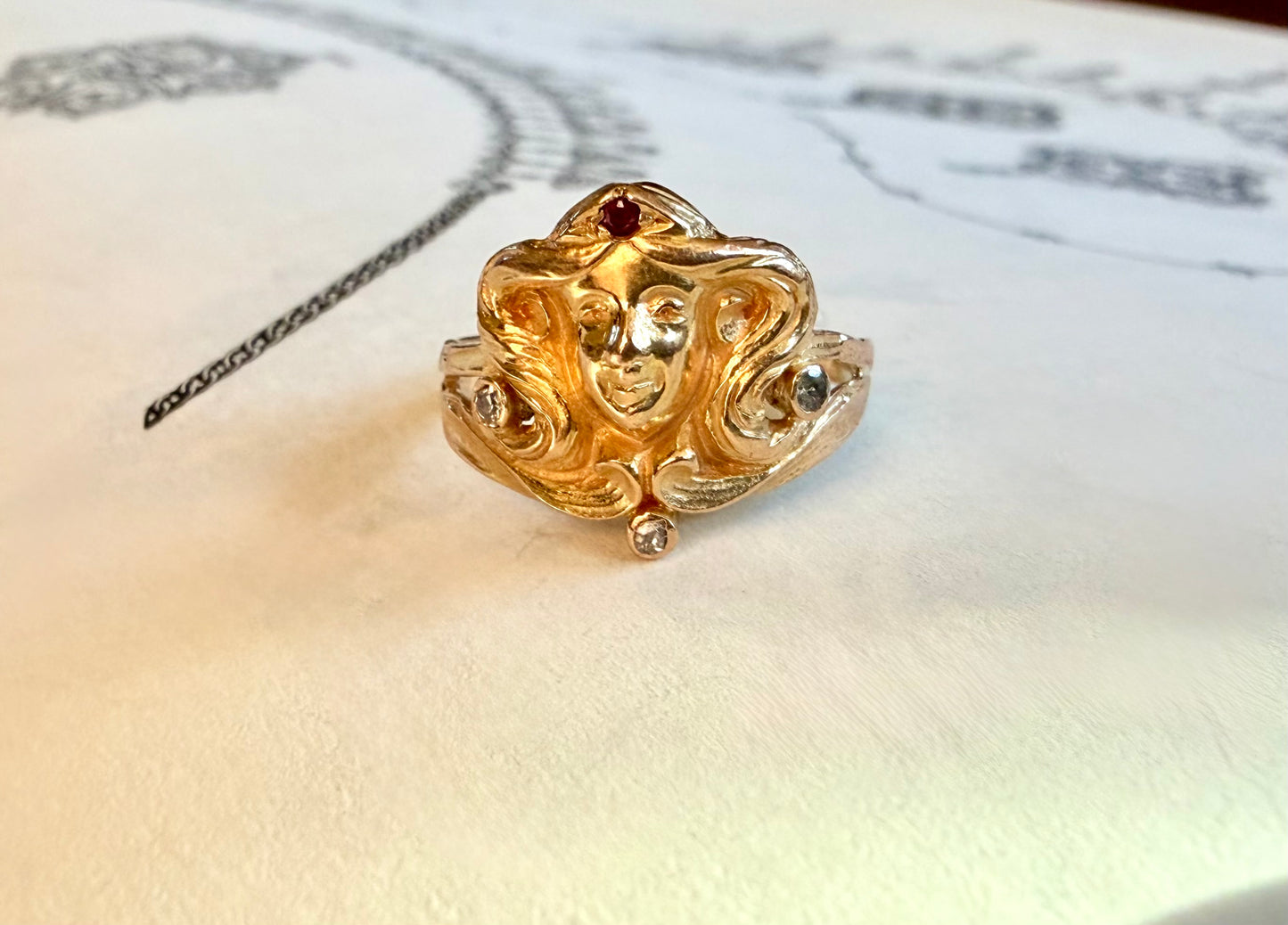 La Déesse ~ Bague Art Nouveau ancienne en or jaune 10 carats, rubis et diamants, représentant une tête de femme.